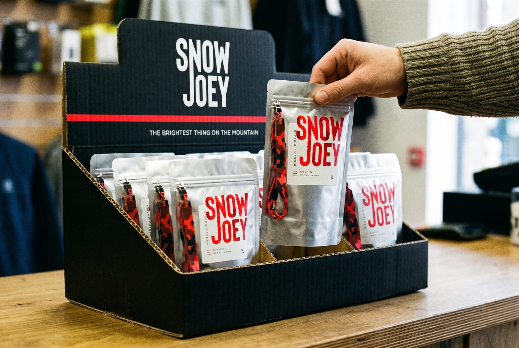 A customer lifting a Snow Joey pack from the counter unit